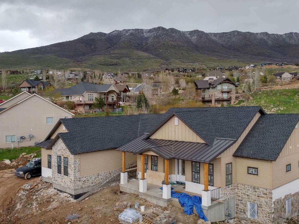 An aerial view of a house under construction with mountains in the background.