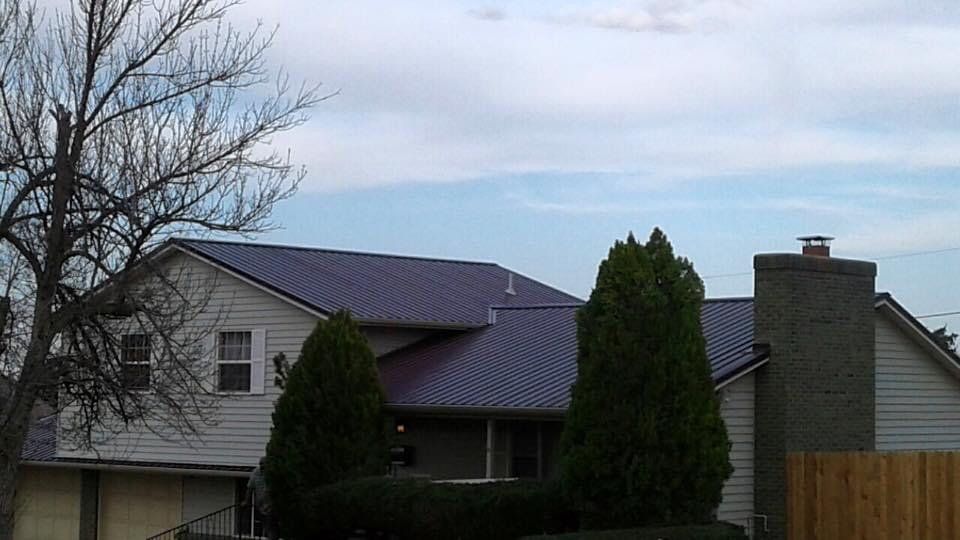A white house with a purple roof and a chimney