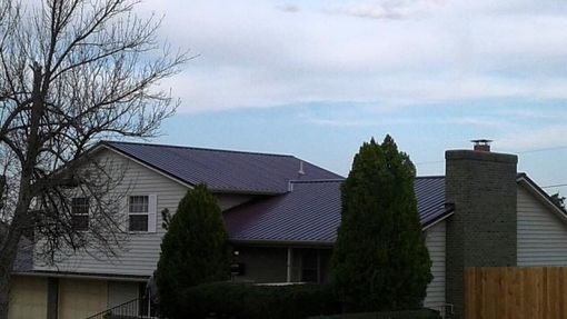 A white house with a purple roof and a chimney