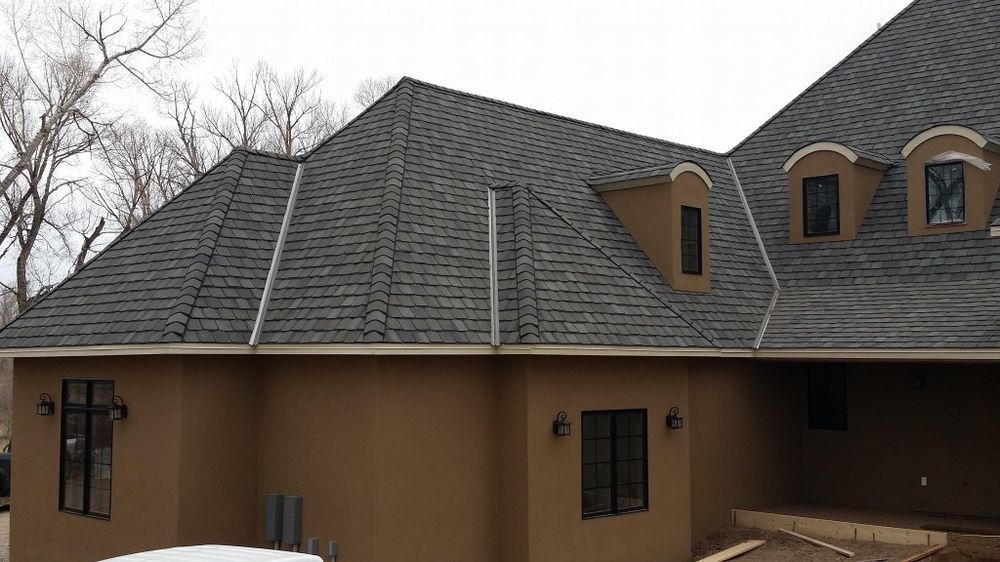 A man is working on the roof of a house.