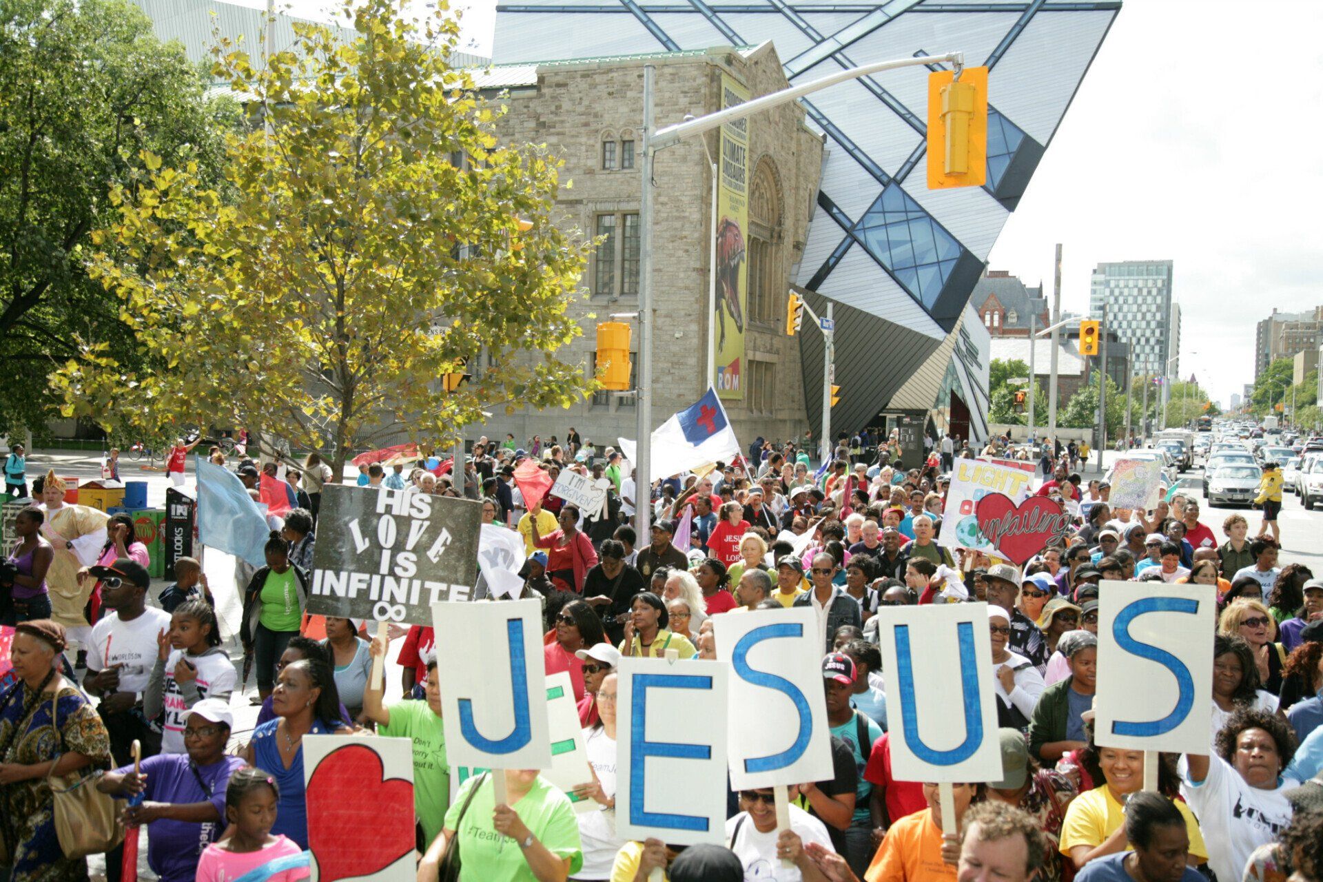 A crowd of people holding signs that say jesus