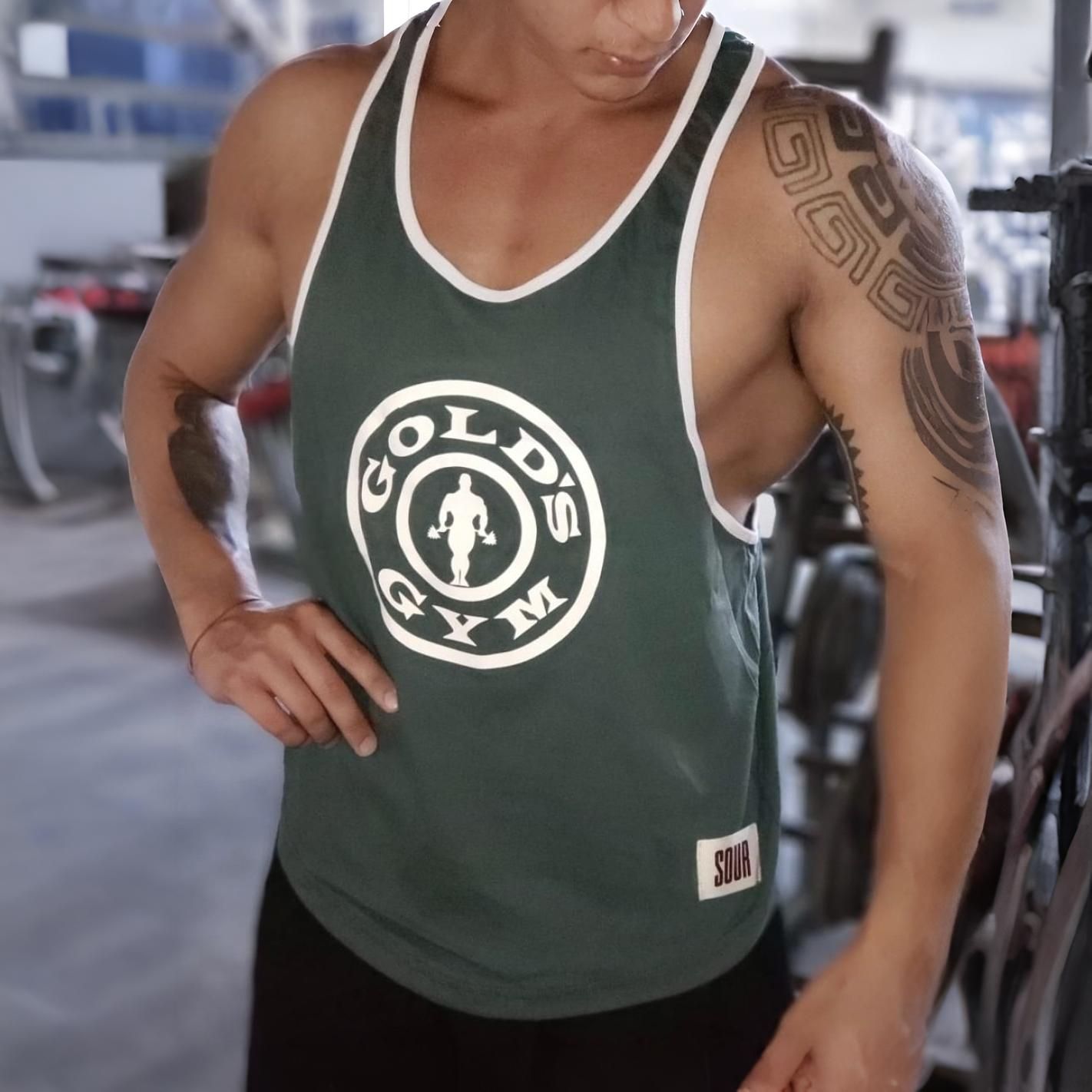 Hombre con camiseta sin mangas de Gold's Gym en el gimnasio