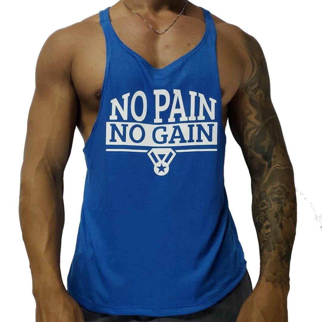 Hombre con camiseta azul sin mangas con el texto "SIN DOLOR NO HAY GANANCIA", mostrando un tatuaje en el brazo.
