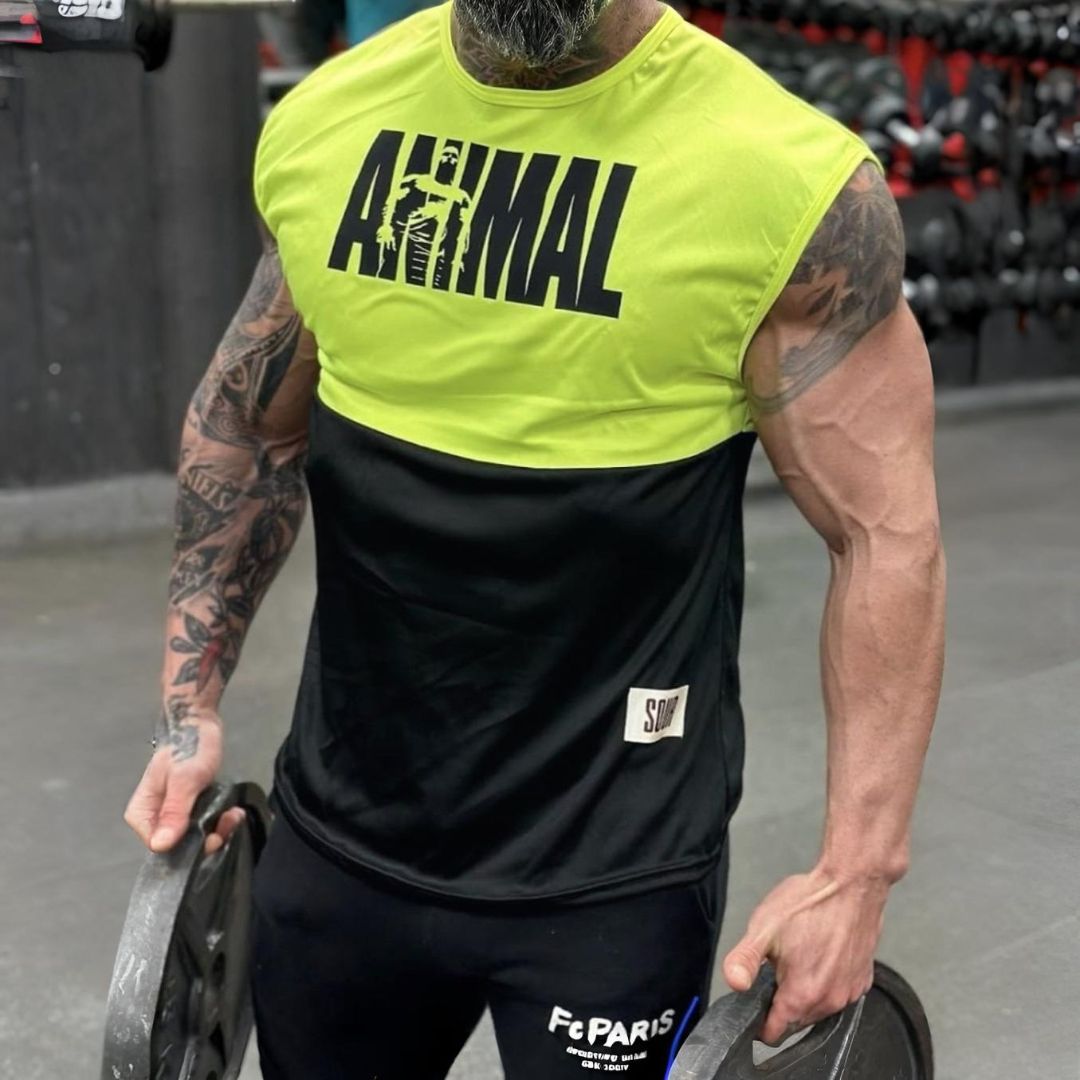 Hombre levantando pesas, vistiendo una camiseta sin mangas verde neón y negra con la palabra "ANIMAL", en un gimnasio.