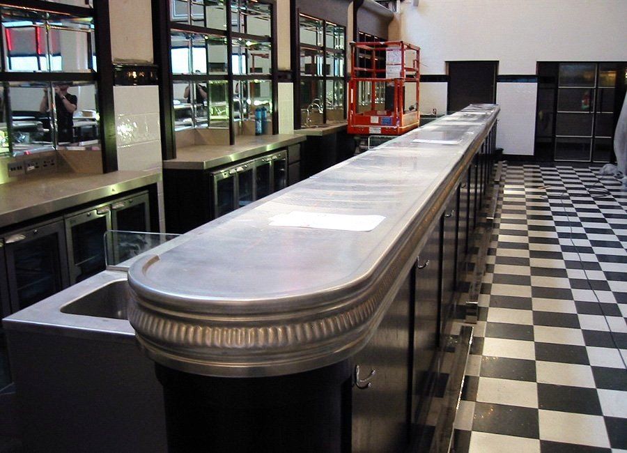 A long counter in a kitchen with a checkered floor