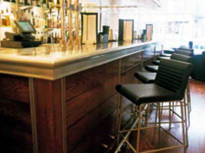 A bar with stools and a counter in a restaurant.