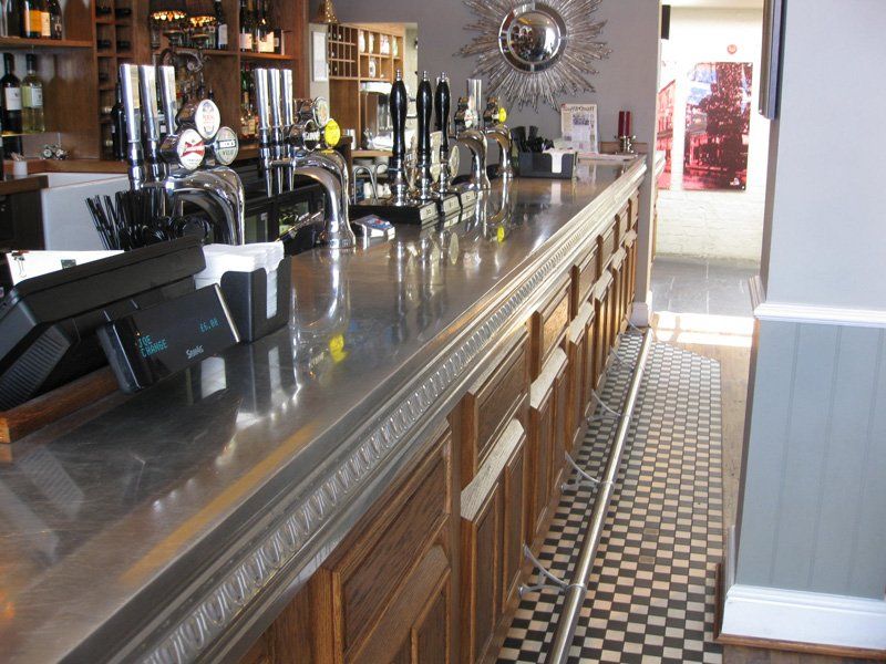 A long bar in a restaurant with a checkered floor