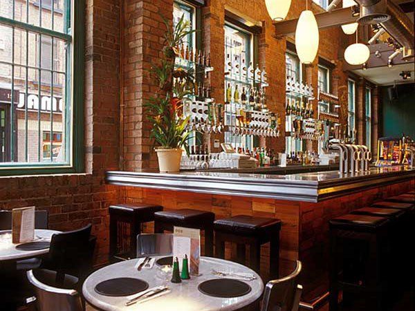 A restaurant with tables and chairs and a bar.