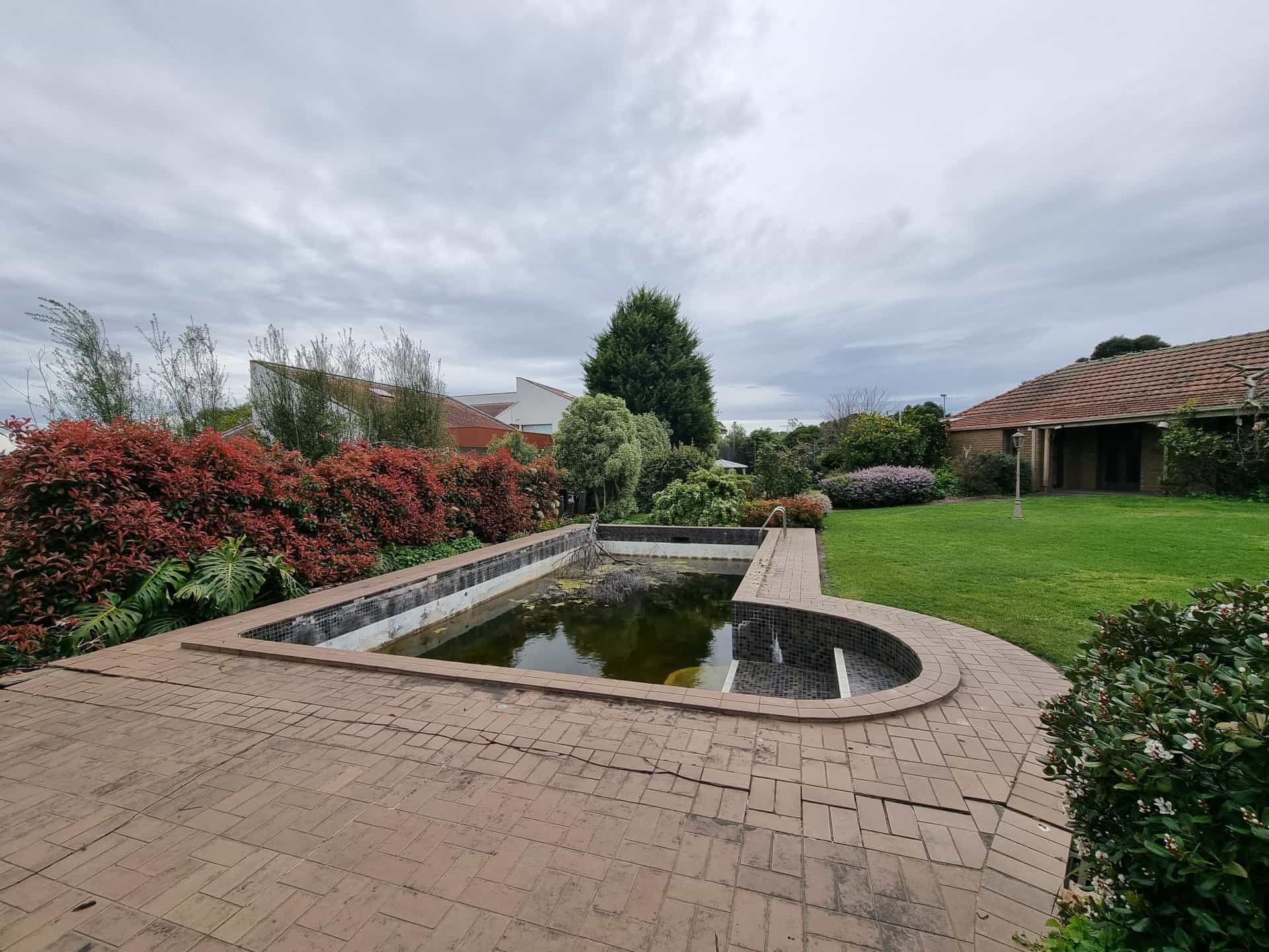 A Backyard With a Rectangular, Overgrown Pond — All Over Pool Removals in Upwey, VIC