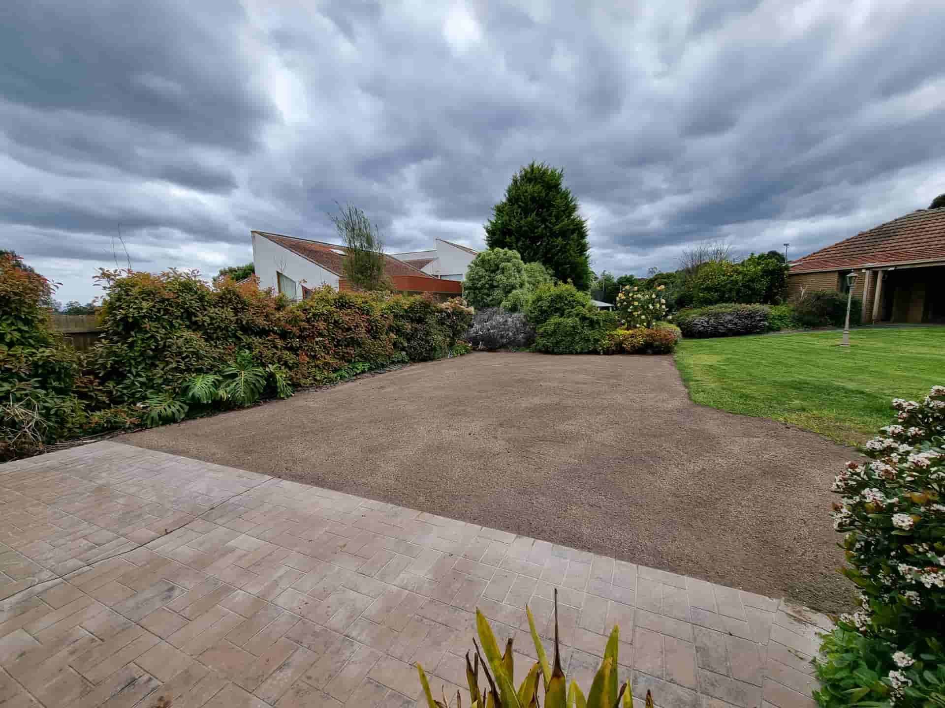 Gravel Driveway Bordered by Greenery, Next to a Grassy Area, Under a Cloudy Sky — All Over Pool Removals in Chadstone, VIC