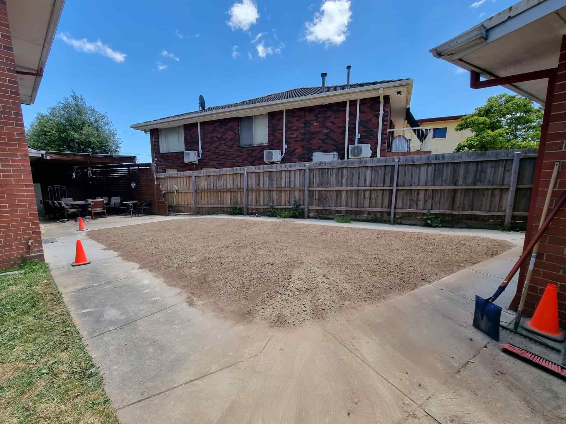 Gravel Covering a Paved Area Between Brick Buildings and a Wooden Fence — All Over Pool Removals in Donvale, VIC