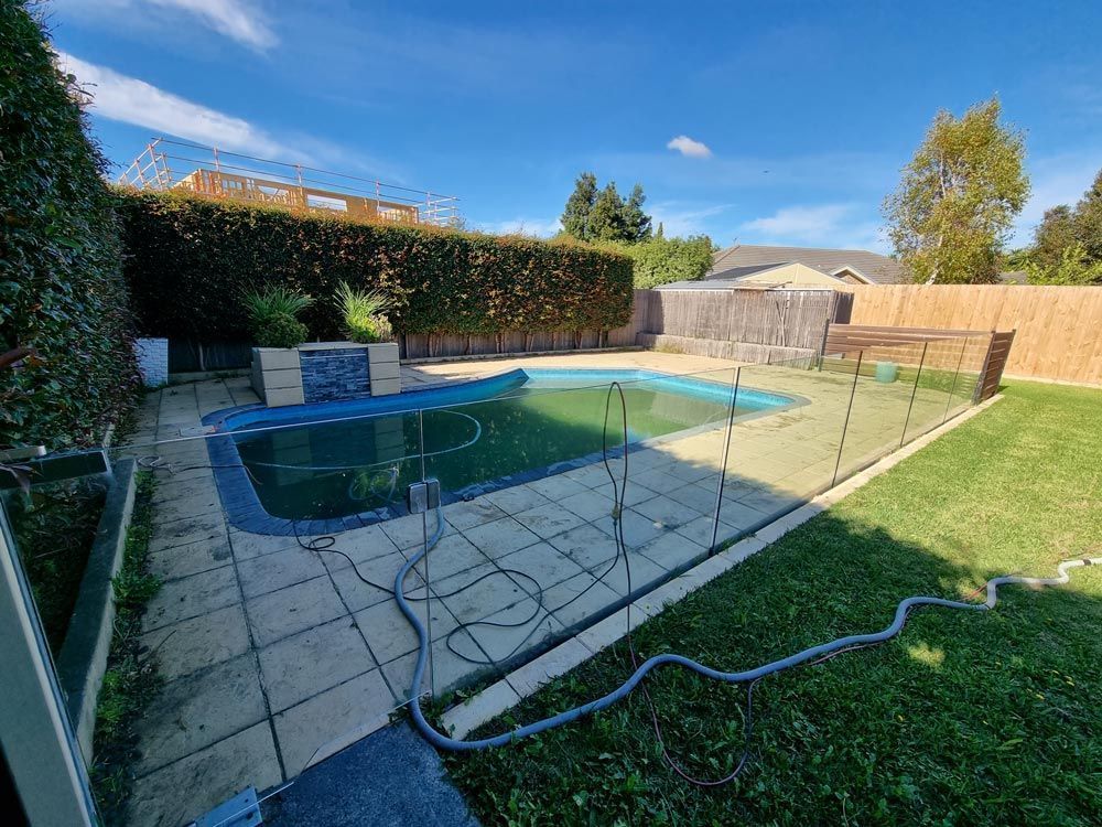 Backyard With Pool, Safety Fence, Green Grass, and Blue Sky — All Over Pool Removals in Upwey, VIC