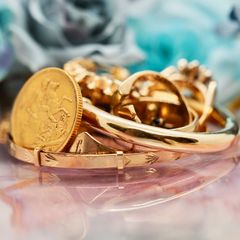 A pile of gold and silver jewellery on a black background