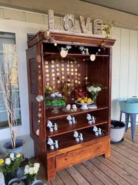 Wooden display cabinet with decorations and collectibles on a porch. 