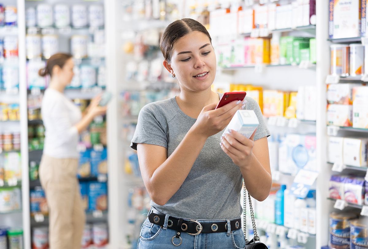 Woman shopper using smartphone scans QR