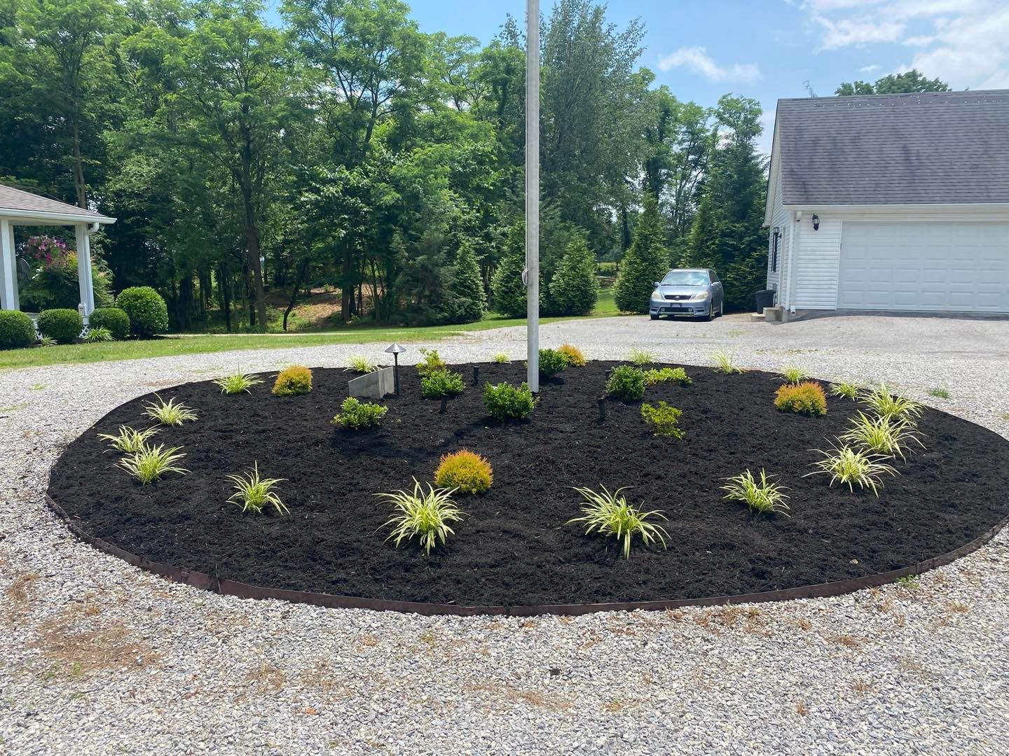 A gravel driveway with a flag pole in the middle of it
