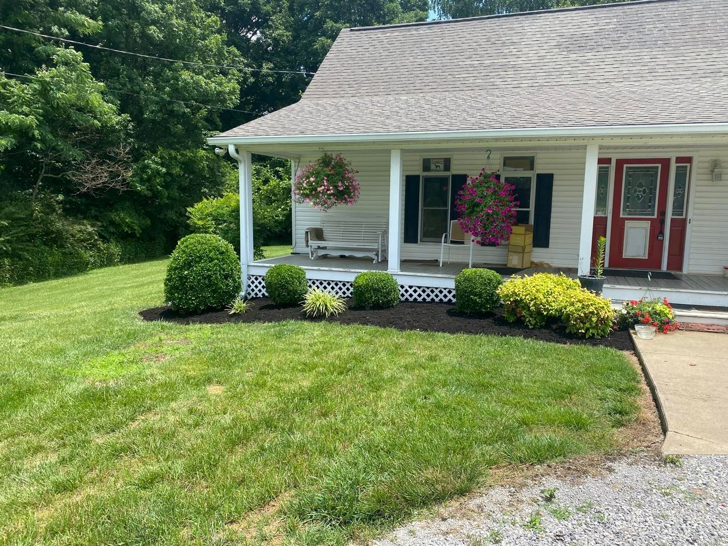 A white house with a red door and a porch.