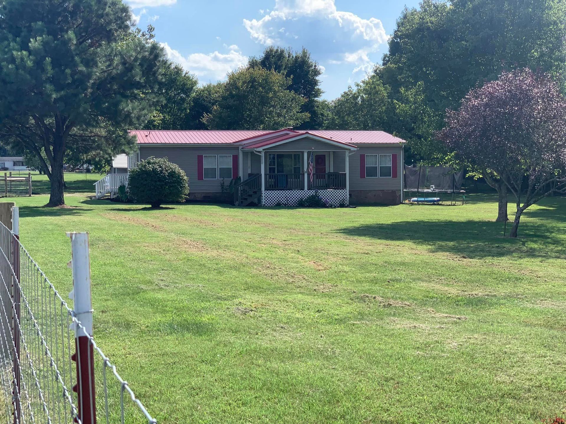A mobile home is sitting in the middle of a lush green field.