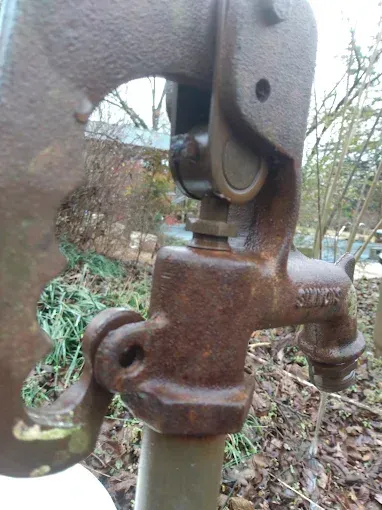 Rusty metal water pump with water flowing. 