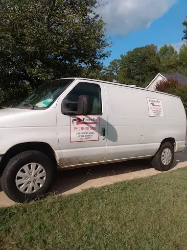 White service van parked on grass, with company logo and text on the side.