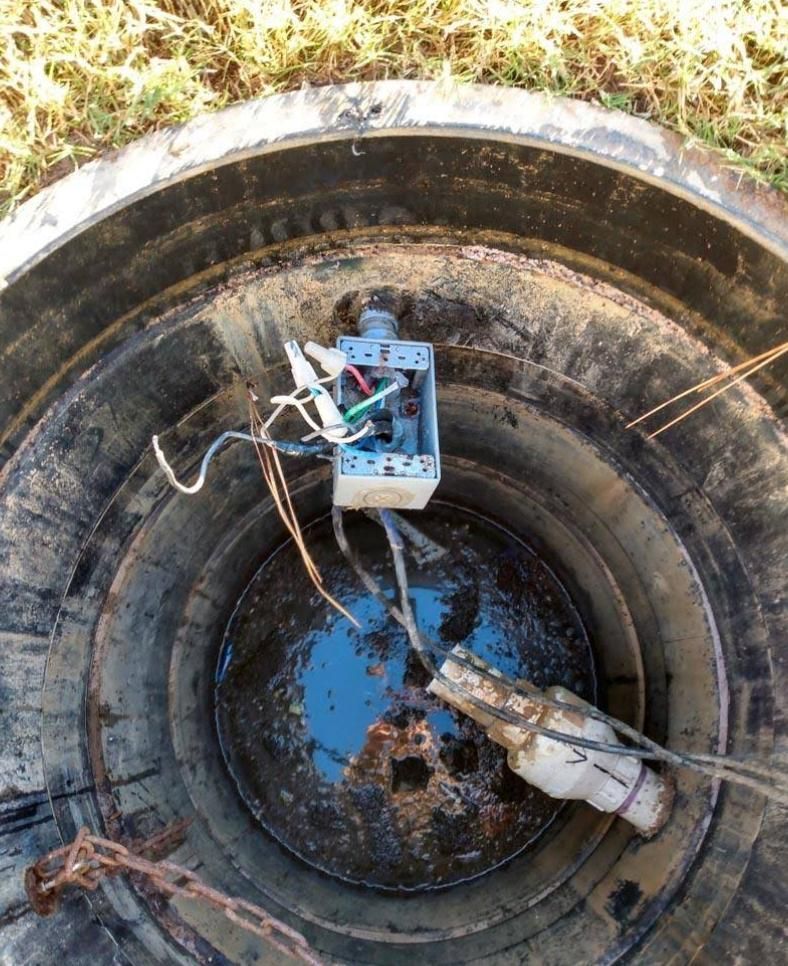 Open well with electrical box and wires; some water at bottom.