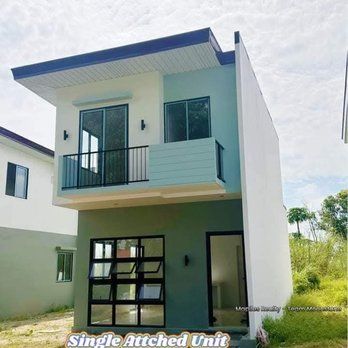 Two-story house with light green and white exterior. The house has a balcony and large windows with a modern design.