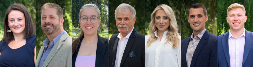A group of people standing next to each other in front of trees.