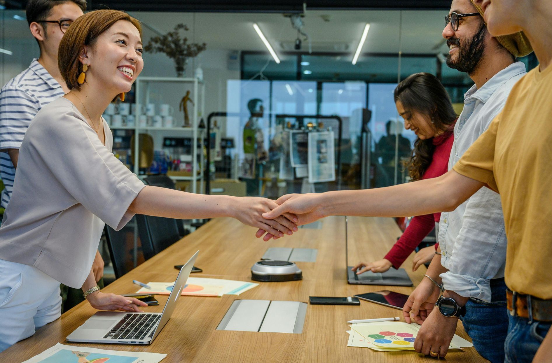 A group of people are shaking hands in a conference room.
