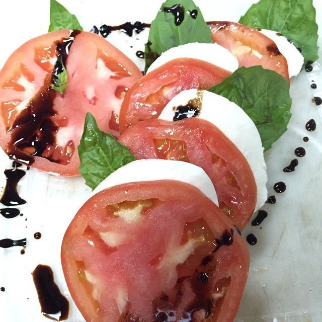 Caprese salad: tomato and mozzarella slices, basil, balsamic glaze.