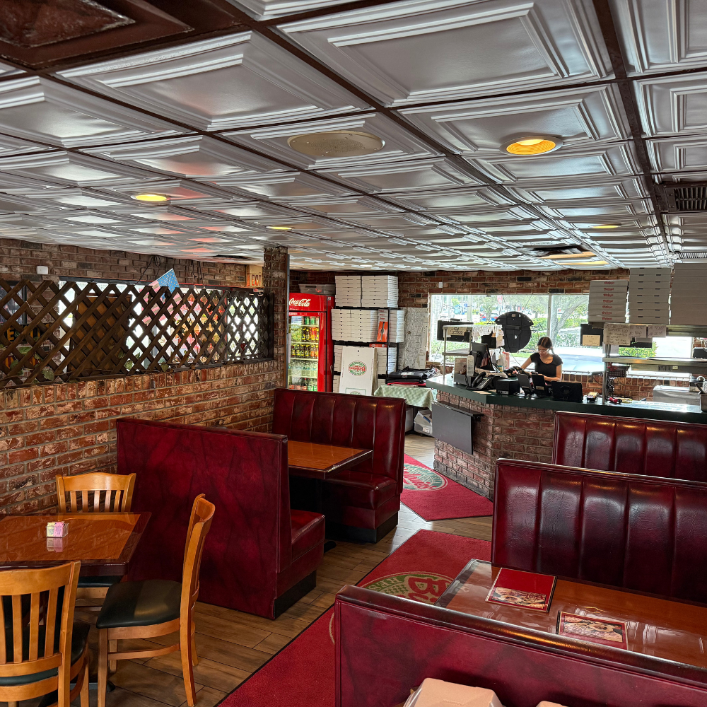 Big Louie’s Pizzeria dining area with checkered ceiling and counter