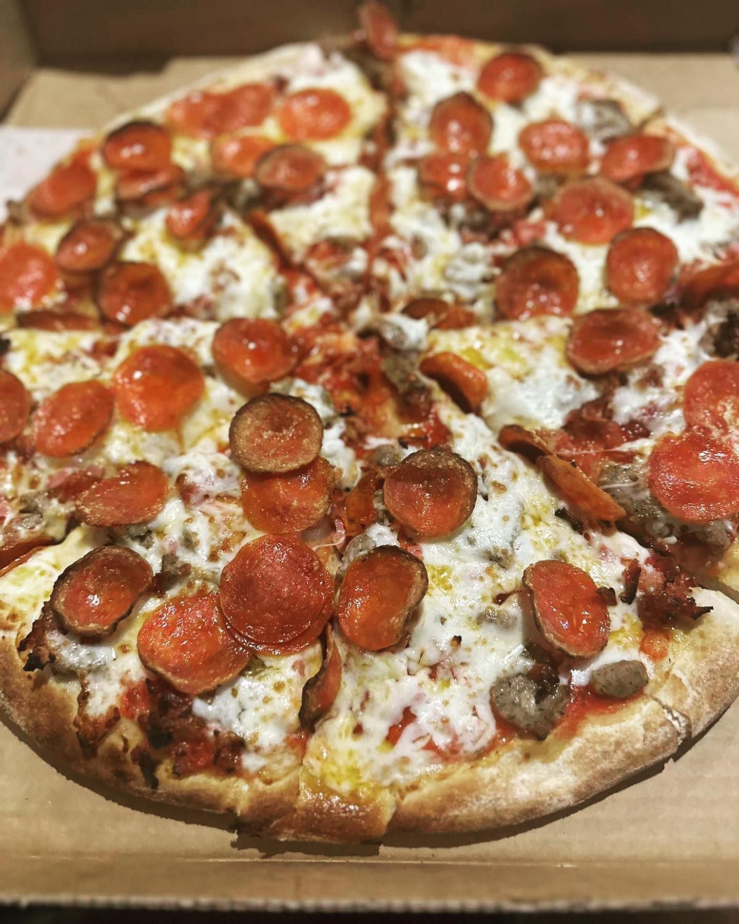 Pepperoni pizza cut into slices in a cardboard box.