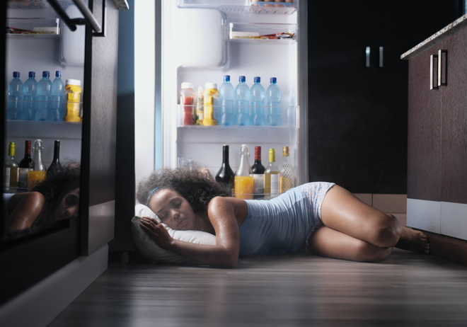 girl sleeping beside the open refrigerator