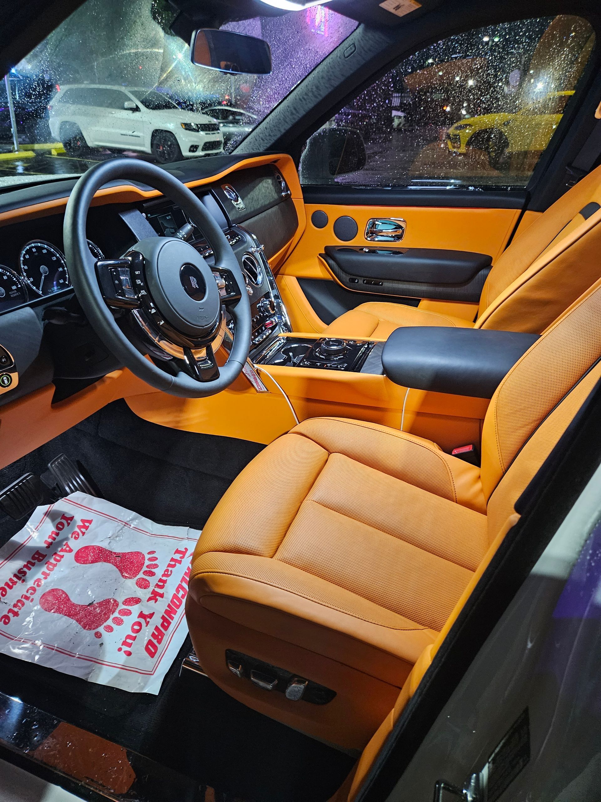 The interior of a car with orange seats and a steering wheel.