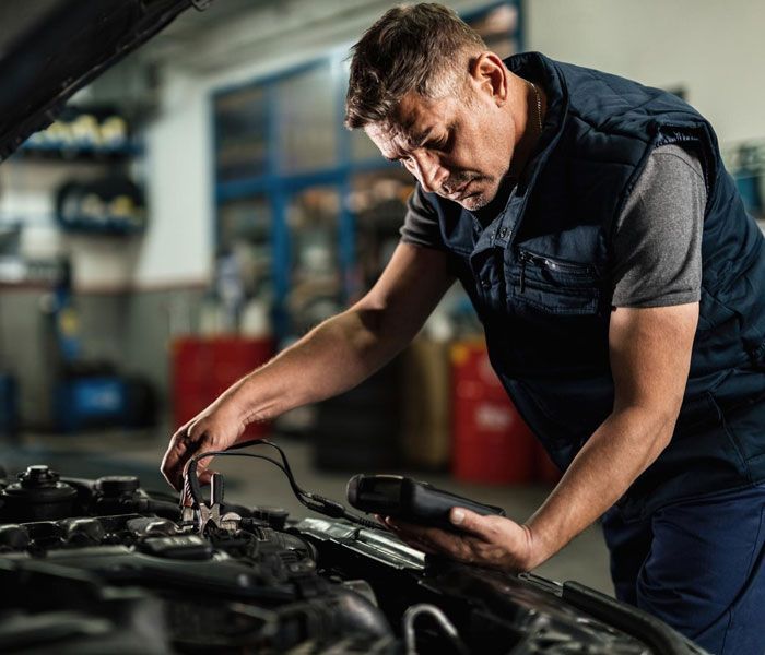 A man is working on a car engine in a garage.