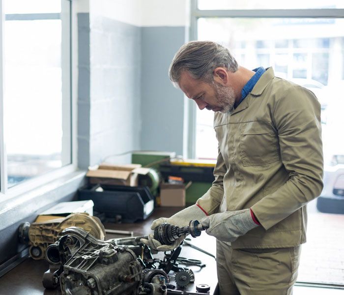 A man is working on a car engine in a garage