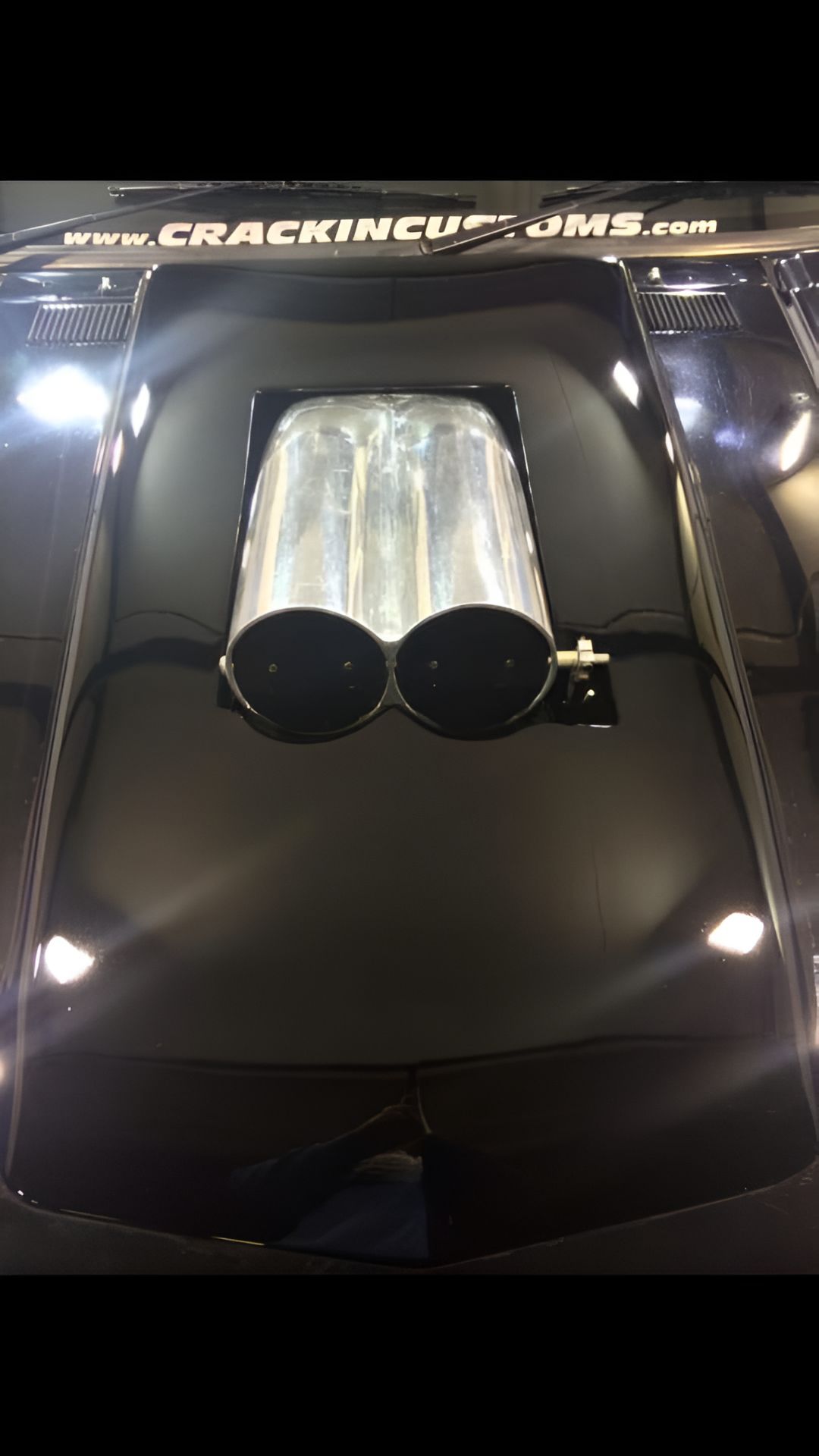 A Close Up of the Hood of a Black Car With Two Exhaust Pipes Coming Out of It — Alice Crash Repairs In Ciccone, NT