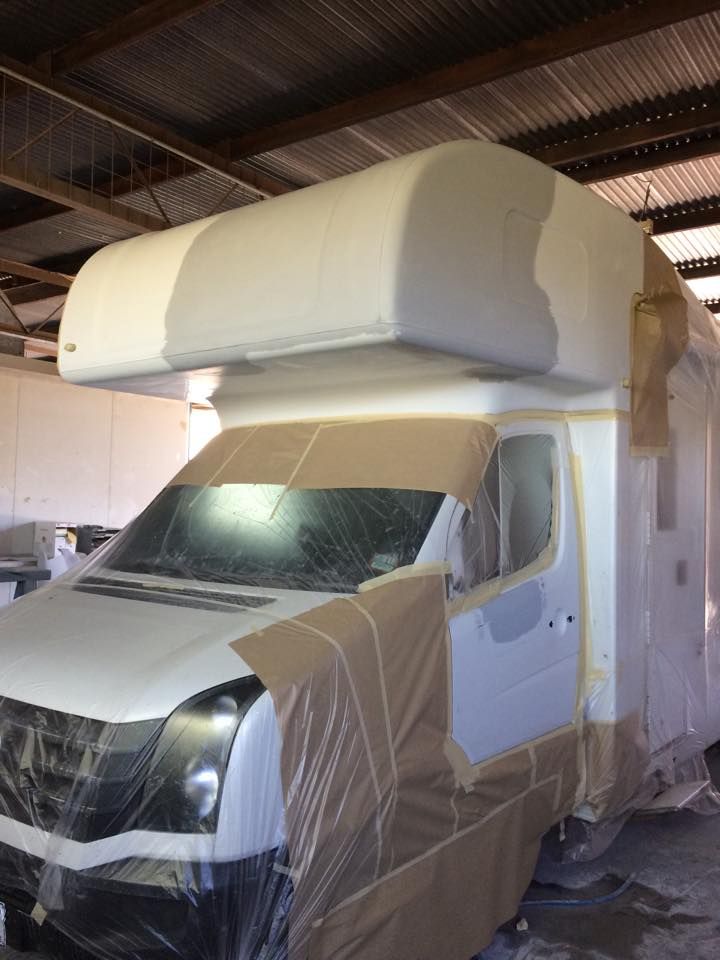 A White Van is Covered in Plastic Wrap in a Garage— Alice Crash Repairs In Ciccone, NT