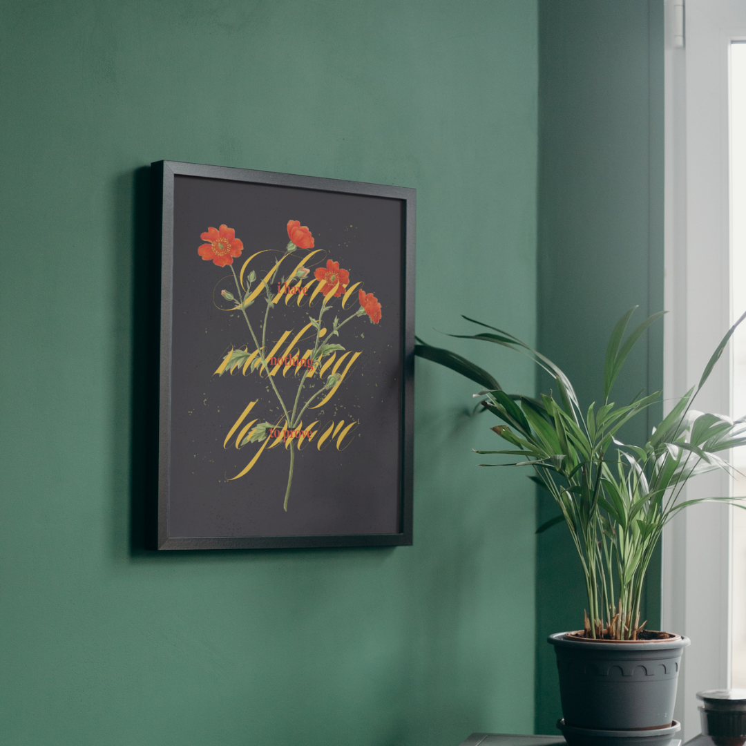 A framed picture on a green wall next to a potted plant.