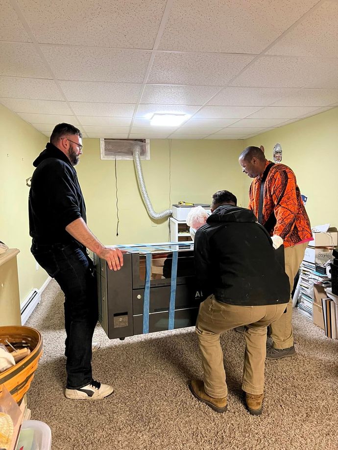 a group of men are moving a couch in a basement .