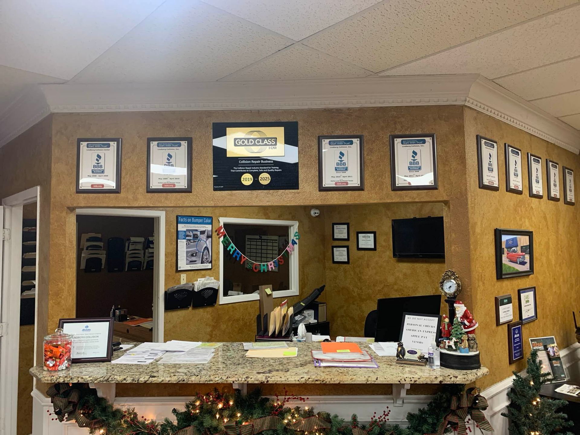Reception desk with awards, Christmas decorations, and paperwork.
