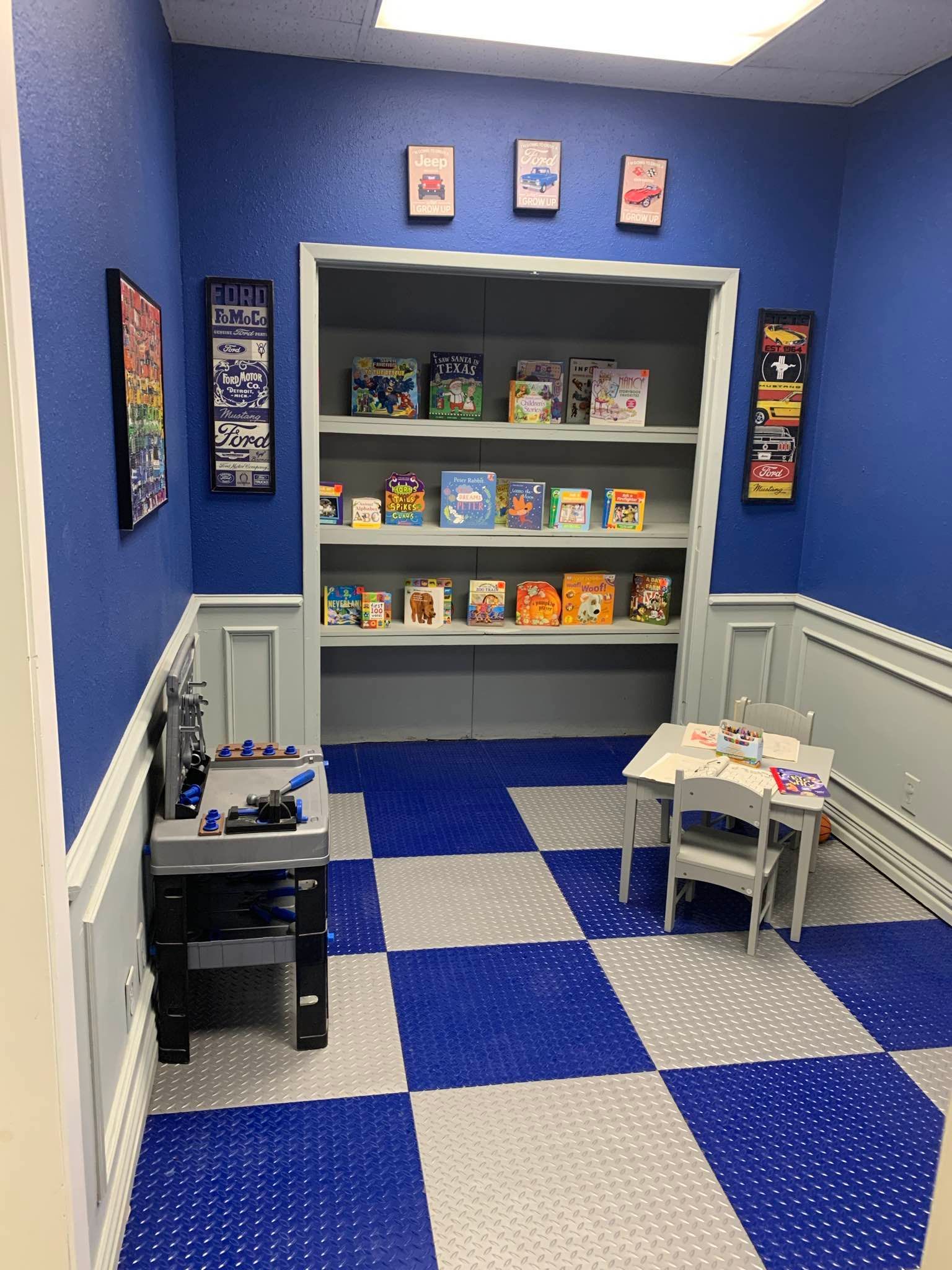 A room with blue walls and a checkered floor has a table and chairs.