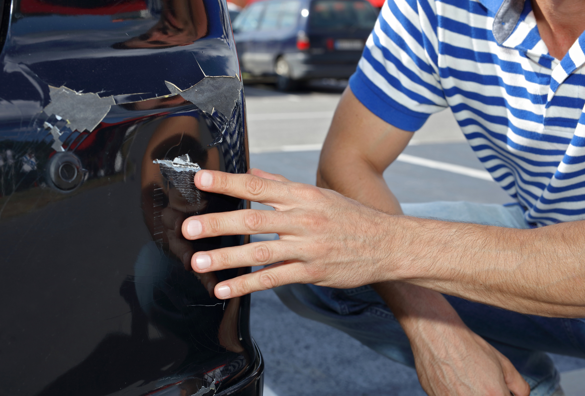 A man is working on the underside of a car.
