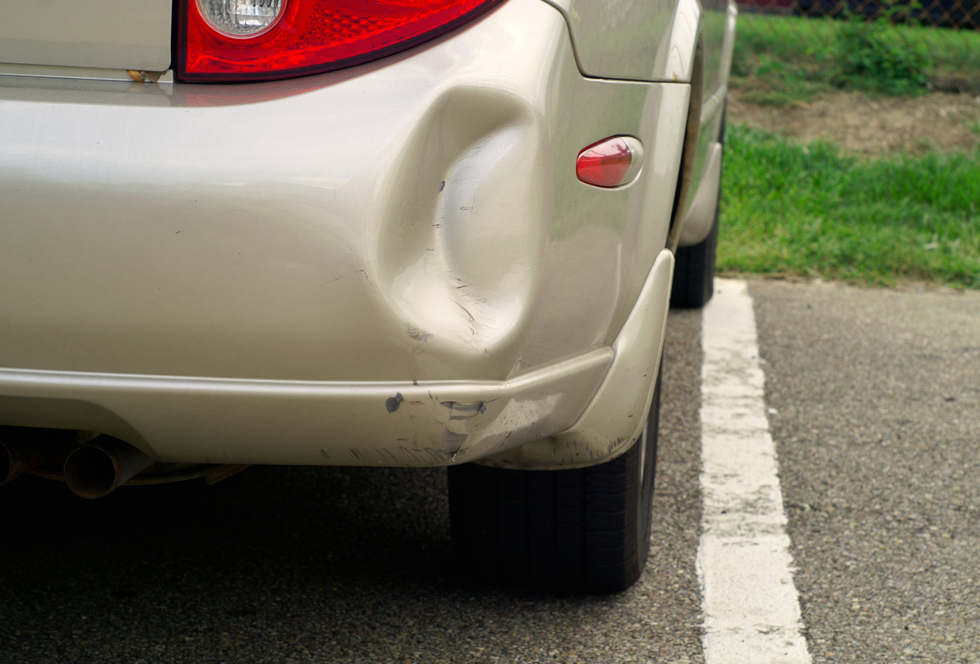 A mechanic is working on the underside of a car in a garage.
