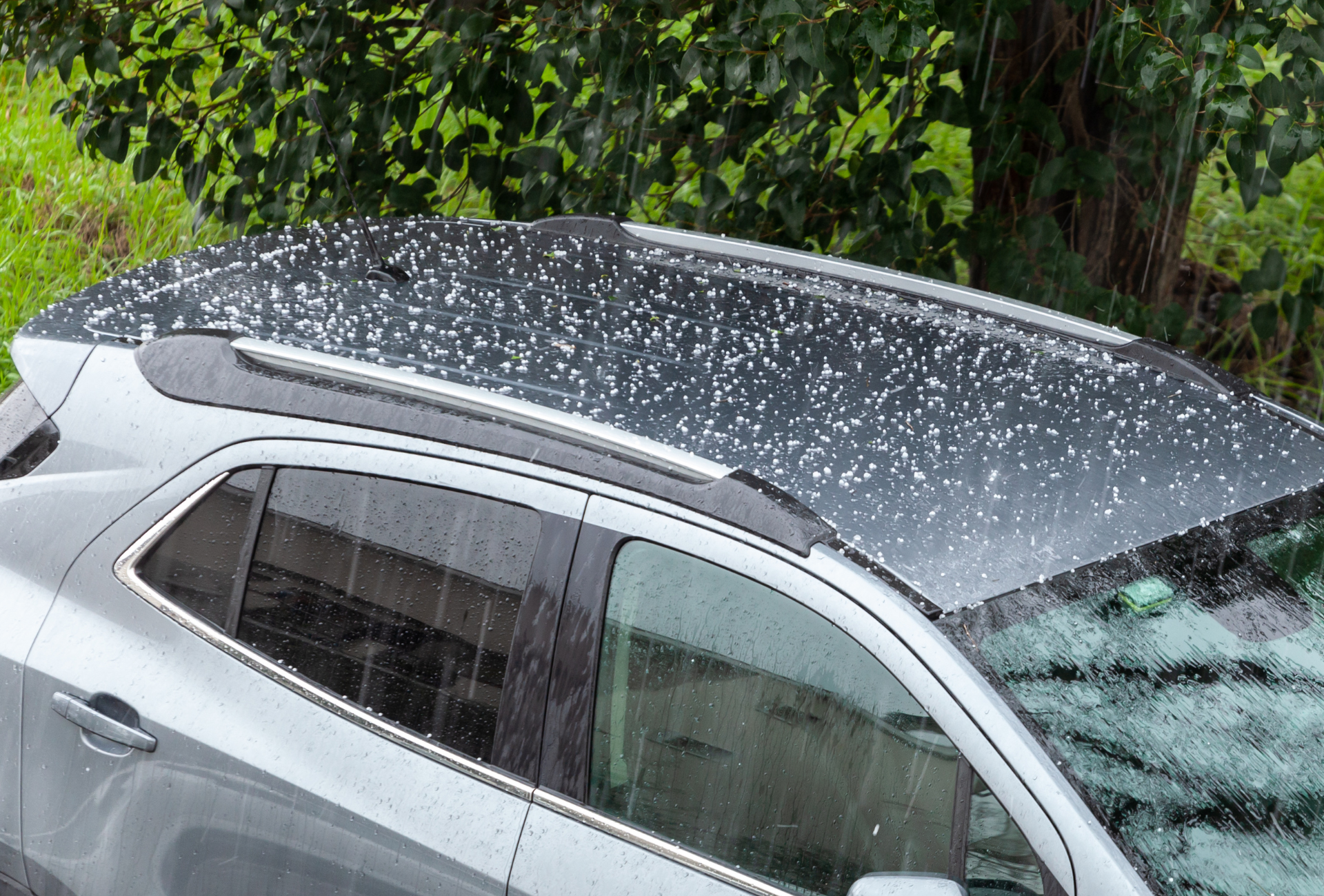 A red car with its hood open in a garage.