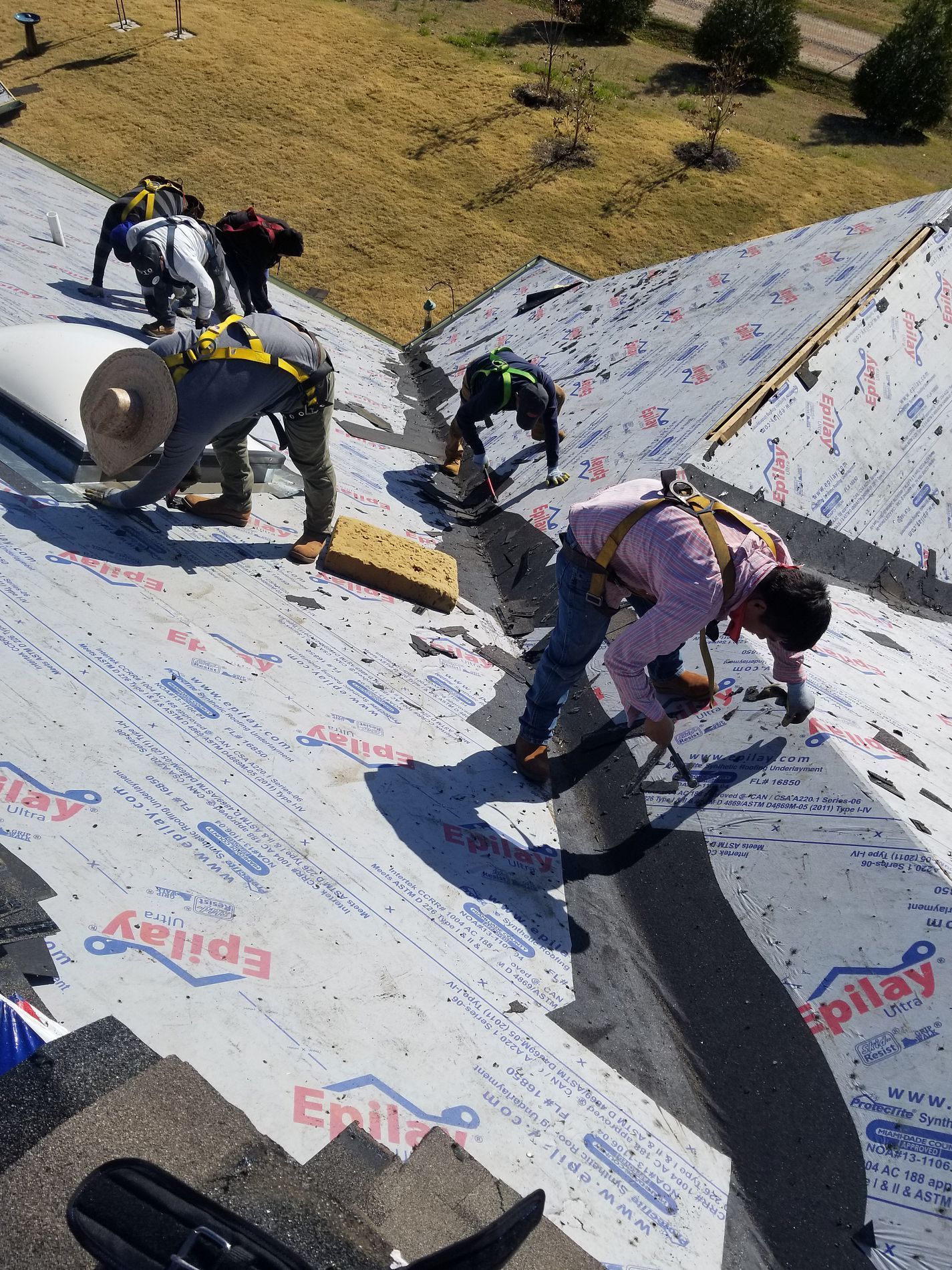 A group of men are working on a roof.