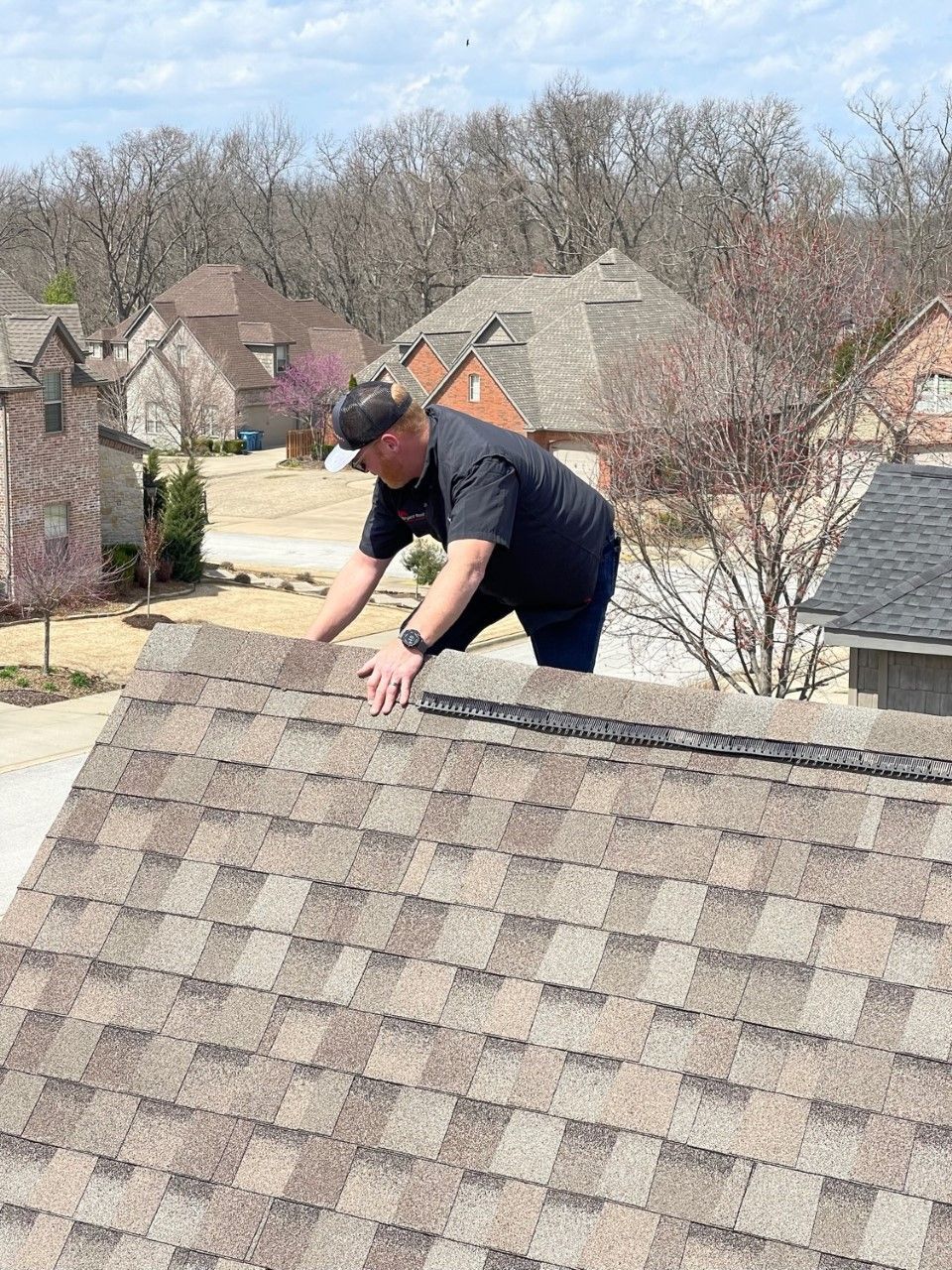 A man is working on the roof of a house.