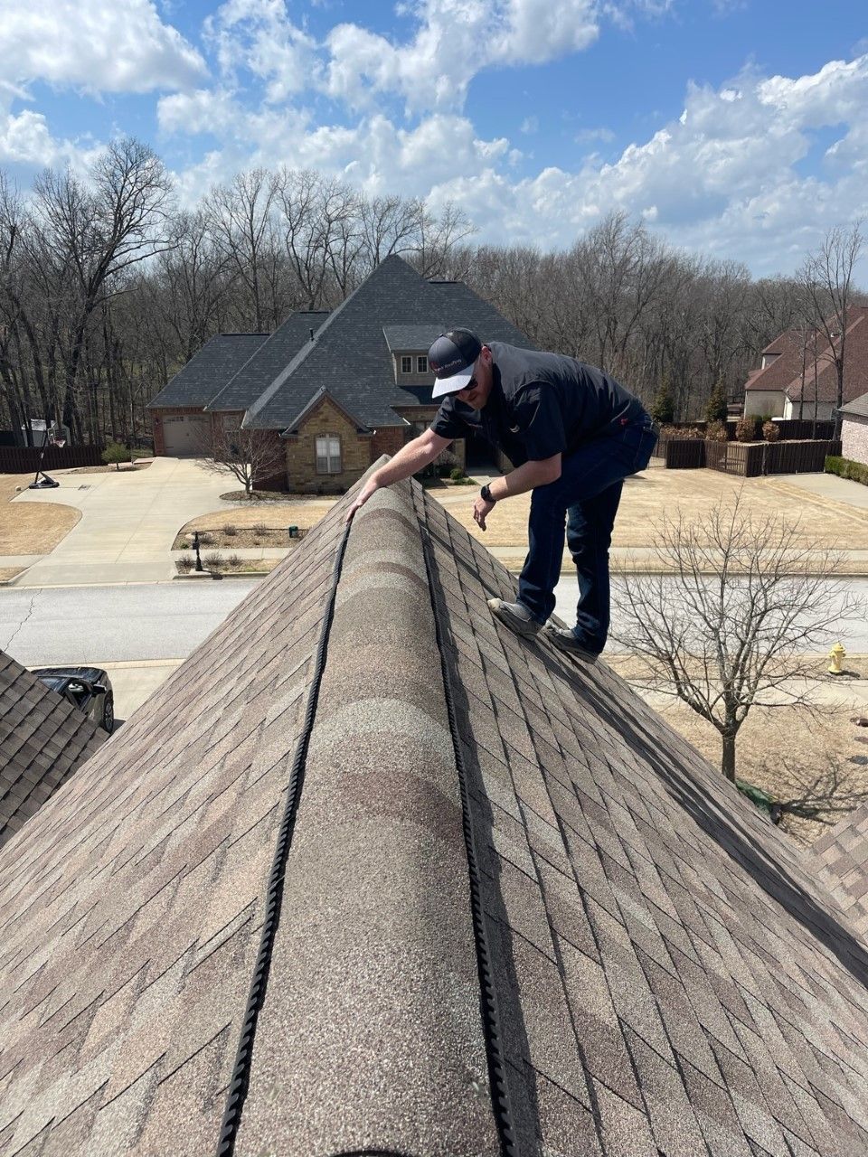 A man is working on the roof of a house.