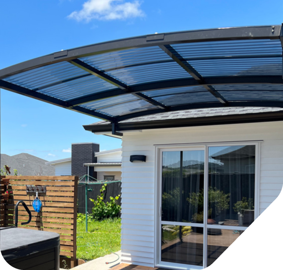 Gray pergola structure over a light-colored house with dark-framed doors and windows.