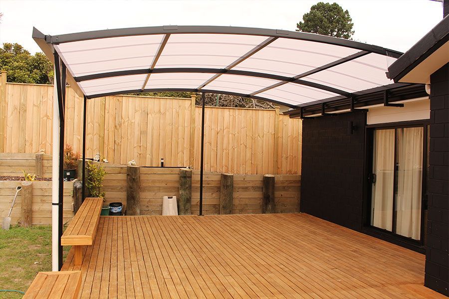 Wooden deck with overhead canopy, bench, and wooden fence.
