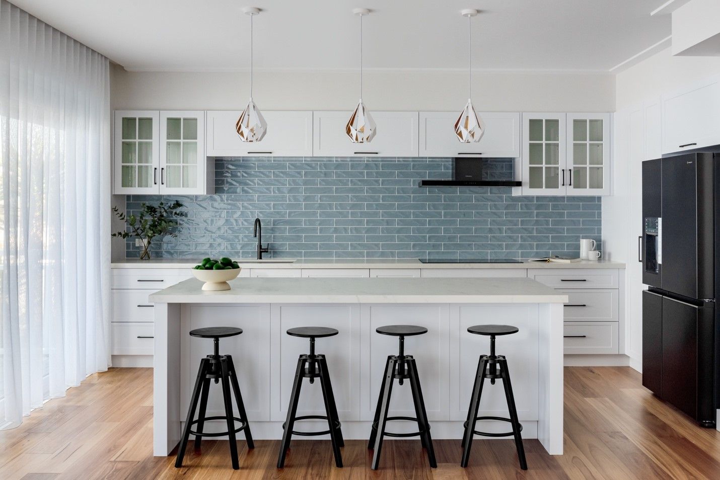 A Kitchen With a Large Island and Stools — QBC Constructions In Gables, NSW